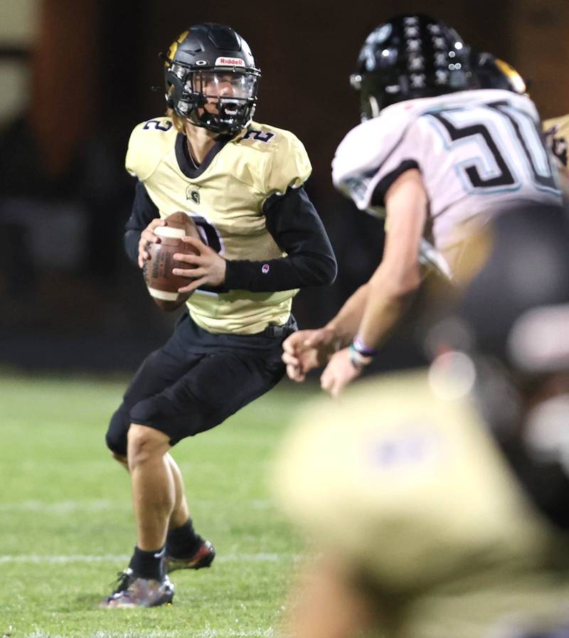 Sycamore's Elijah Meier looks for a receiver as Woodstock North's Scott Bauer applies the pressure during their game Friday Oct. 7, 2022, at Sycamore High School.