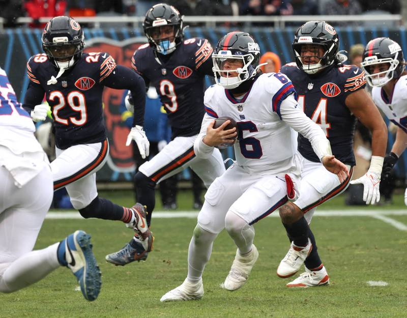 New York Giants quarterback Jaxson Dart scrambles away from the Chicago Bears pass rush Sunday, Nov. 9, 2025, during their game at Soldier Field in Chicago.