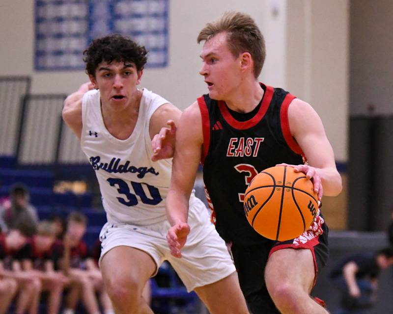 Glenbard East's Danny Snyder, right, dribbles down the court while being defended by Riverside-Brookfield's Liam Enright (30) during the game on Tuesday Feb. 3, 2026, held at Riverside-Brookfield High School High School.