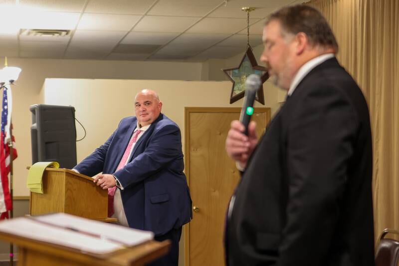Bureau County States Attorney Candidate Dan Anderson speaks to crowd at debate whilst his opponent Brad Popurella watches on Wednesday, October 2, 2024 at Moose Lodge in Princeton.