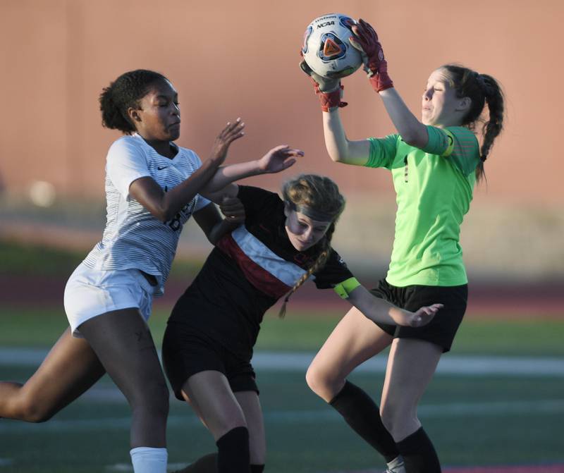 Lincoln-Way Central goalkeeper Alexa Hadley grabs the ball as teammate Christine Erdman blocks out Metea Valley’s Tyra King in the Class 3A IHSA state girls soccer semifinal game in Naperville on Friday, June 3, 2022.