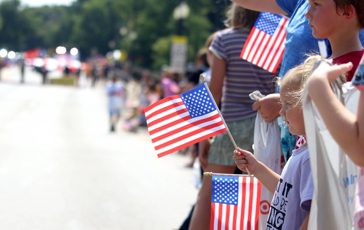 Children wave flags as part of the Founders’ Days parade along Route 62 in Algonquin July 27, 2024.