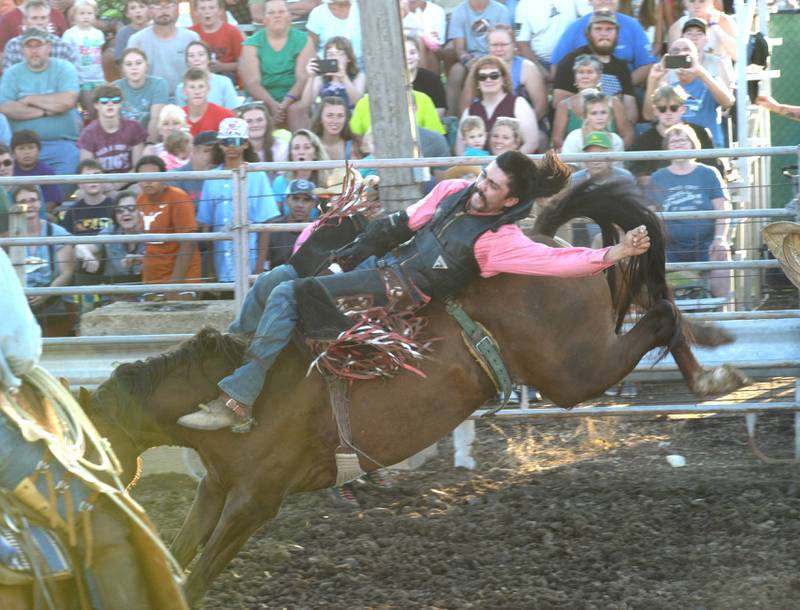 Rueben Saucedo tries to stay on a bucking bronco during the T and A rodeo at the Lee County Fair on Saturday, July 29, 2023.