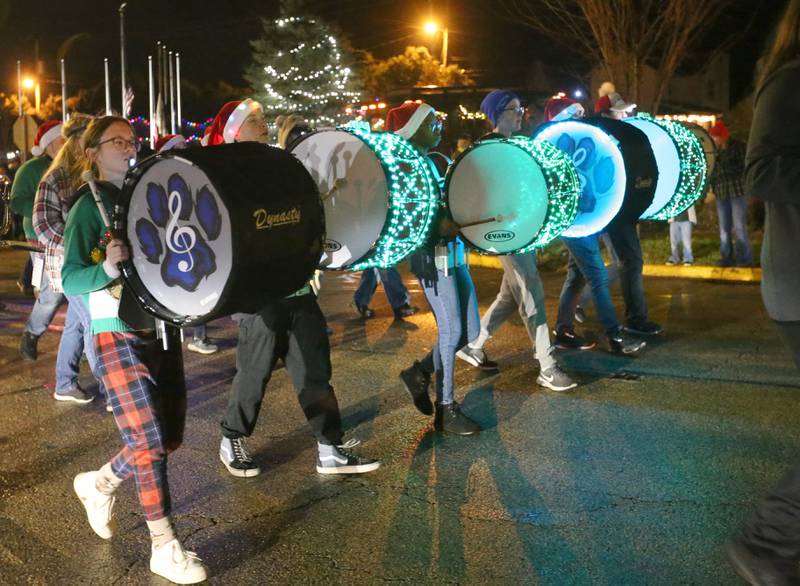 Members of the Princeton High School Marching Band march with light-up drums in the inaugural Lighted Christmas Parade on Friday, Dec. 1, 2023 in Princeton.
