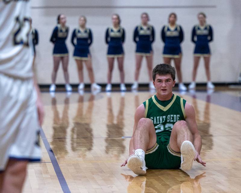 St. Bede's Aj Hermes (22) sits on floor looking towards Marquette's Luke McCullough (23) after being pushed down during the Class 1A Regional Boys Basketball Championship game on Friday, Feb. 27, 2026 at Serena High School.