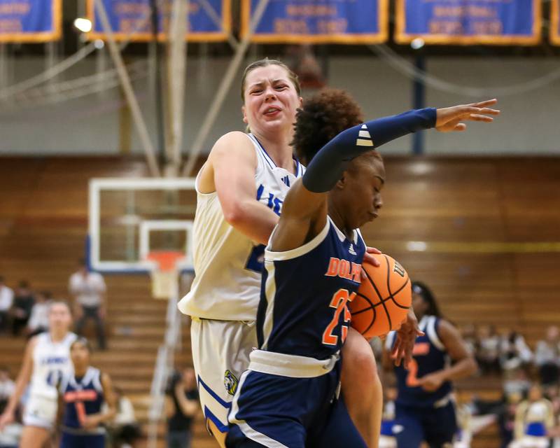 Lyon's Gwen Smith (21) gets tied up while driving to the basket during their Class 4A Lyons Sectional semifinal basketball game between Lyons vs Young. Feb 25, 2025 in La Grange.