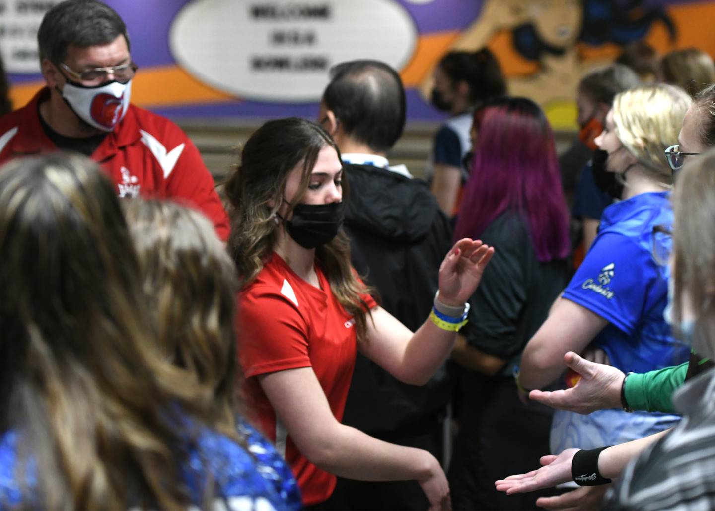Oregon's Ava Wight is congratulated by another coach after throwing a strike while competing in the state bowling finals at the Cherry Bowl in Cherry Valley on Saturday. Pictured at left is Oregon coach Al Nordman.