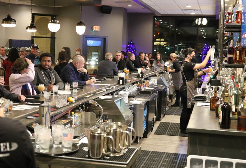 Attendees to the ribbon cutting at Keg & Kernel by Tangled Roots Brewing Company, enjoy a beer Wednesday, Dec. 8, 2021, after the ceremony at the restaurant at 106 East Lincoln Highway in DeKalb.