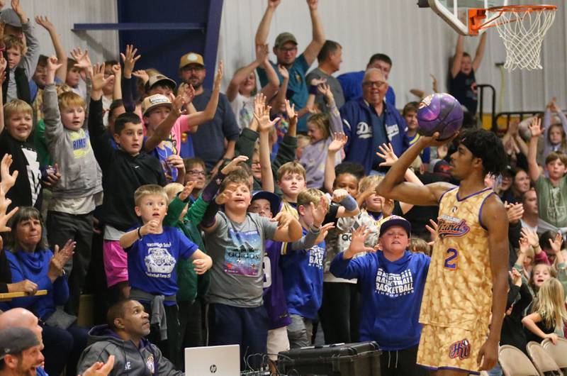 Harlem Wizards player Devale Johnson, (Too Tall) throws a Wizards basketball to the crowd during the Harlem Wizards event on Tuesday, Oct. 28, 2025 in Pannebaker Gymnasium at Logan Jr. High School in Princeton.