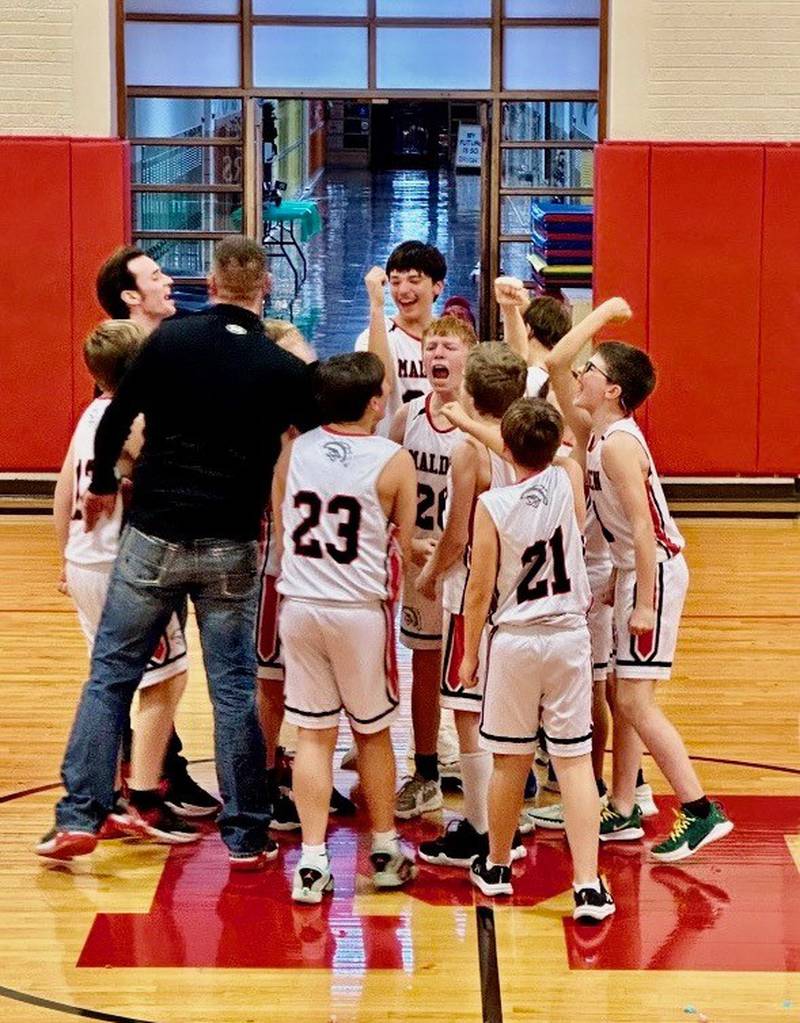 Coach Nick Lower and the Malden Musketeers celebrate their first BVEC championship after upending 8-time defending champion DePue 35-31 Thursday night at Malden.