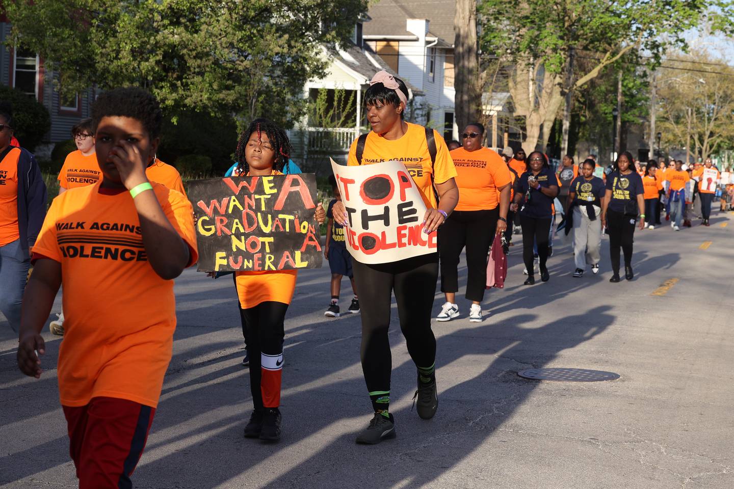 Sophia Henderson, 8, carries a sign opposing gun violence alongside her mother Erika Franklin, both of Kankakee, as they walk with about 100 participants along Station Street in Kankakee during the 2nd Walk Against Gun Violence on Tuesday, April 29, 2025.