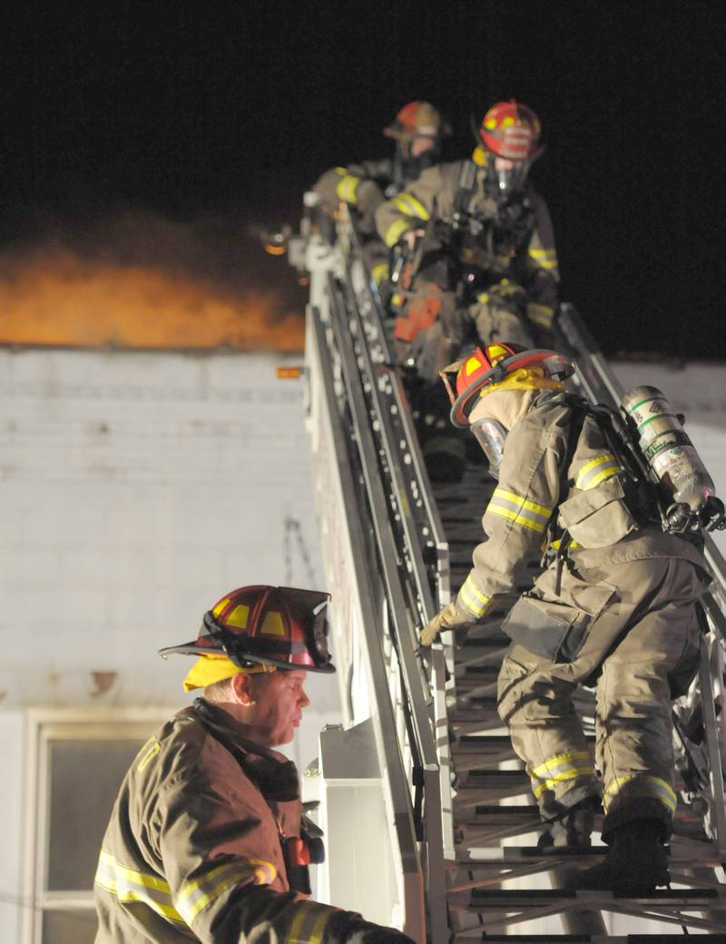 Firefighters enter burning building above Skoogs Pub & Grill on Sunday, May 10, 2015 downtown Utica.