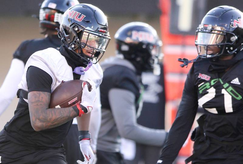 Northern Illinois University receiver Keyshaun Pipkin carries the ball as safety Muhammed Jammeh closes in during spring practice Friday, April 7, 2023, in Huskie Stadium at NIU in DeKalb.