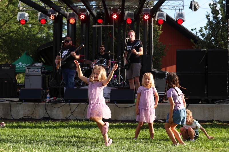 Remy Strysik, 5, of Bourbonnais, dances around with friends as Kankakee-based rock band Deconstructing Jim performs on the Hill Stage during Merchant Street MusicFest on Friday, July 25, 2025.