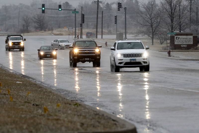 Vehicles travel along Lake Avenue near Catalpa Lane in Woodstock on Wednesday, Feb. 22, 2023, as a winter storm that produced rain, sleet, freezing rain, and ice moved through McHenry County.