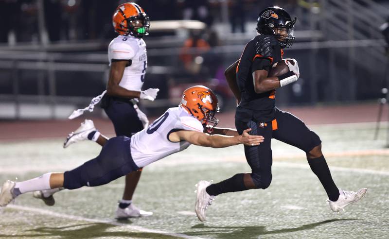 DeKalb’s Davon Grant outruns Naperville North's Matthew Murphy for a long gain on a pass to set up a DeKalb touchdown during their game Friday, Sept. 22, 2023, at DeKalb High School.