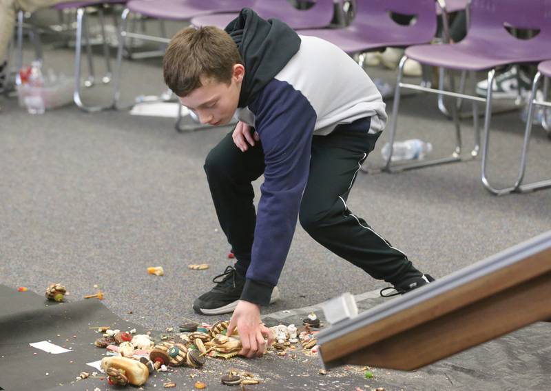 Lucas Straughn of Oglesby Washington School, picks up the remaining pieces his edible car at the finish line after racing during the 29th annual Edible Car Contest on Wednesday, Feb. 26, 2025 in the IVCC Cafeteria.