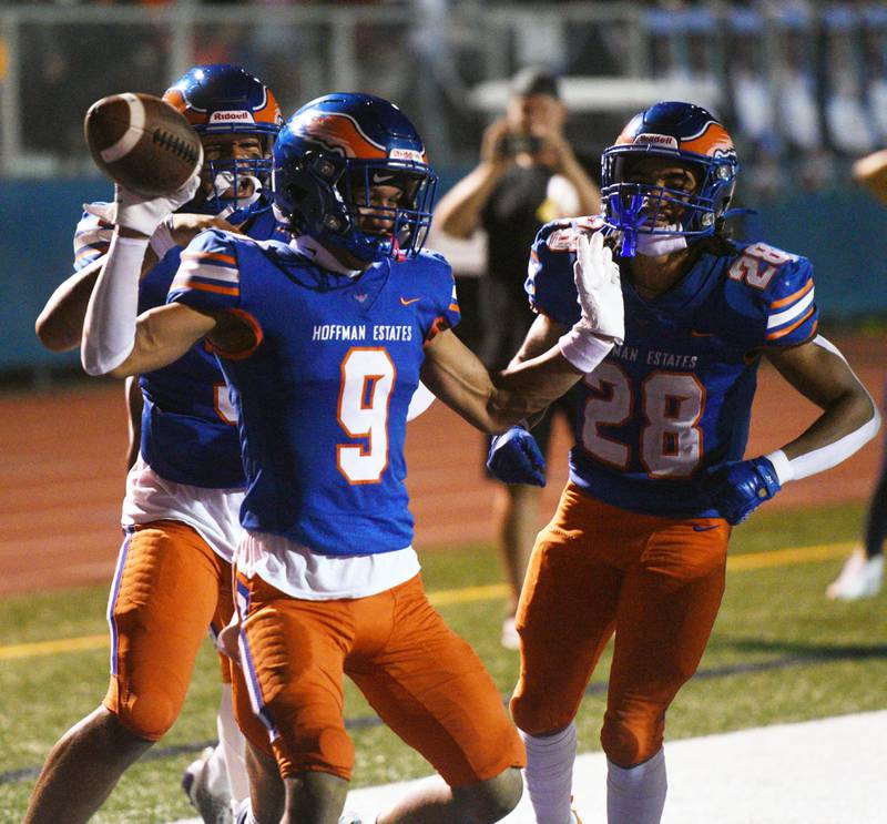 Hoffman Estates’ Jerami Harden middle, celebrates a first-quarter touchdown with teammates Nate Cleveland, left, and Landon Ford during Friday’s football game in Hoffman Estates.