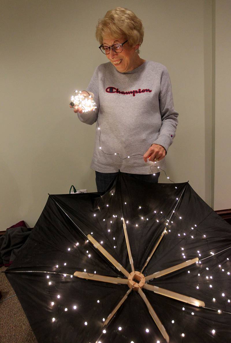 Judy Marusich, of Grayslake works on putting lights on one of the umbrellas used for the Grayslake Greenery Garden Club tree which will be on display for the Giving Trees exhibit at the Grayslake Heritage Center & Museum.