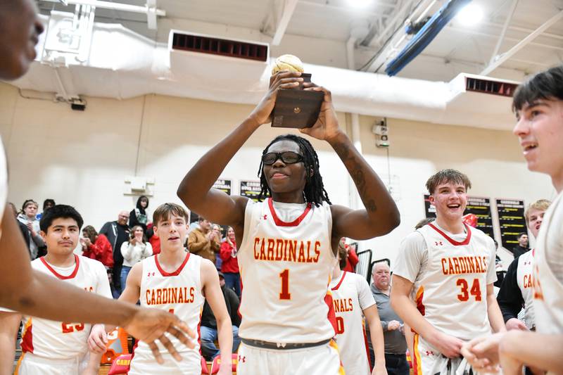 St. Anne's Chris Link hoists the River Valley Conference championship trophy overhead on Friday, Feb. 14, 2025, after the Cardinals defeated Beecher 70-38 at St. Anne Community High School.