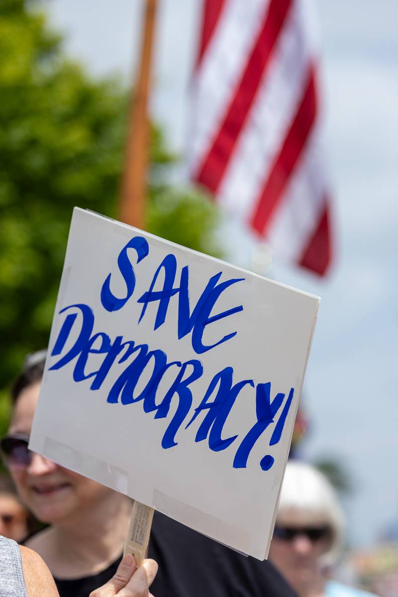 Sign that reads “Save Democracy” is held at the “No Kings” protest on Saturday, June 14, 2025 at Rotary Park in Princeton.