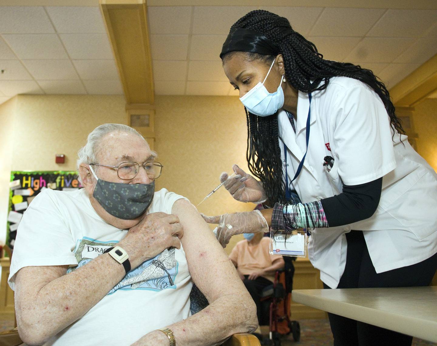 John Gregg, a resident of the Timbers of Shorewood, receives the COVID-19 vaccine from Walgreens Pharmacists Leslie Jones-Hunter at Timbers of Shorewood on January 7, 2021, in Shorewood, Ill.