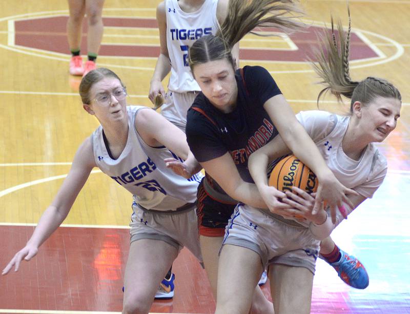 Princeton’s Danika Burden and Payton Brandt fight for a rebound with Metamora’s Baylie Nena in the 2ndt period Tuesday at the Ottawa Holiday Tournament.