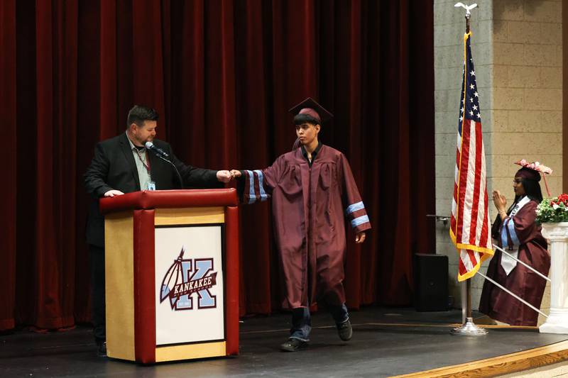 Kankakee High School graduate Kenny Moreno fist bumps Assistant Principal Jason Worden, left, as he crosses the stage during the summer commencement ceremony at the high school on Tuesday, July 29, 2025.
