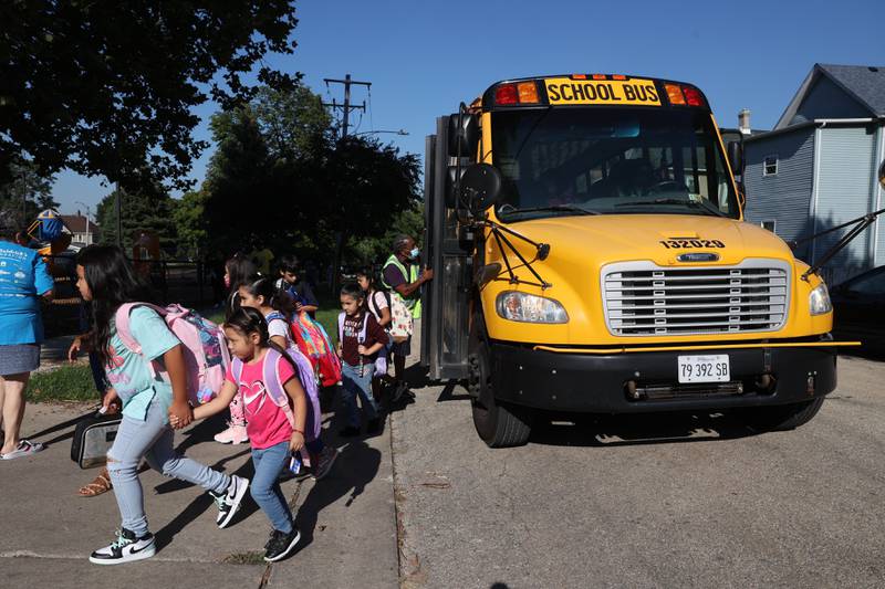 Students exit a bus on the first day of school at Woodland Elementary School in Joliet. Wednesday, Aug. 17, 2022, in Joliet.