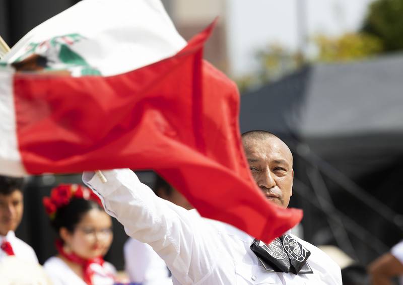 Roberto Flores of Sterling waves the Mexican flag during the Mexican national anthem Saturday, Sept. 13, 2025, at the start of Taste of Fiesta in Rock Falls.