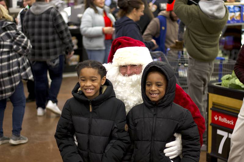 Joliet Police Officer Tony Lakota, dressed as Santa Claus, poses for photos with children participating in the 36th annual Santa's Cops event on Saturday, Dec. 6, 2025, at Walmart, 401 Illinois Route 59, in  Shorewood.