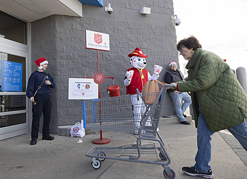 Sterling firefighter Kyle Bell and the Sterling fire mascot greet shoppers Friday, Dec. 15, 2023 at the Sterling Walmart. The fire and police departments both manned the Salvation Army buckets on Friday for a friendly competition on who could collect the most money. Winner gets the hold the City Trophy and have bragging rights the next year.