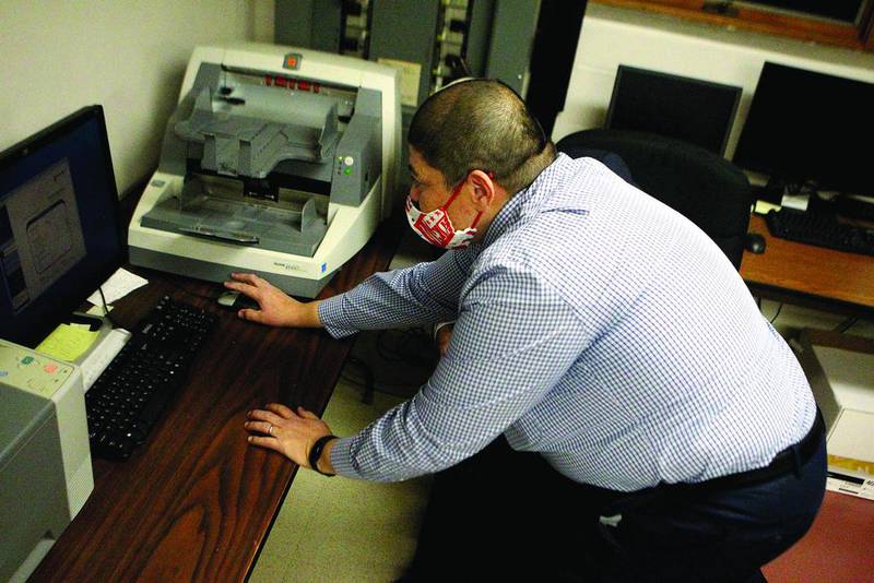 Raymond Esquivel, Kane County director of elections, pushes the start button for the tabulations of early voting and vote by mail ballots to begin at 7 p.m. after polls closed on Nov. 3 at the Kane County Clerk office in Geneva.