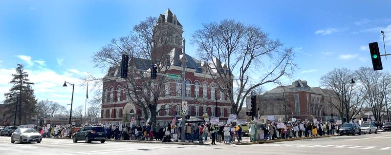 People line the sidewalk along state Route 2 and 64  in downtown Oregon, Illinois, during the No Kings rally organized by Indivisible of Ogle County on Saturday, March 28, 2026. The 2-hour afternoon event drew an estimated crowd of 650.