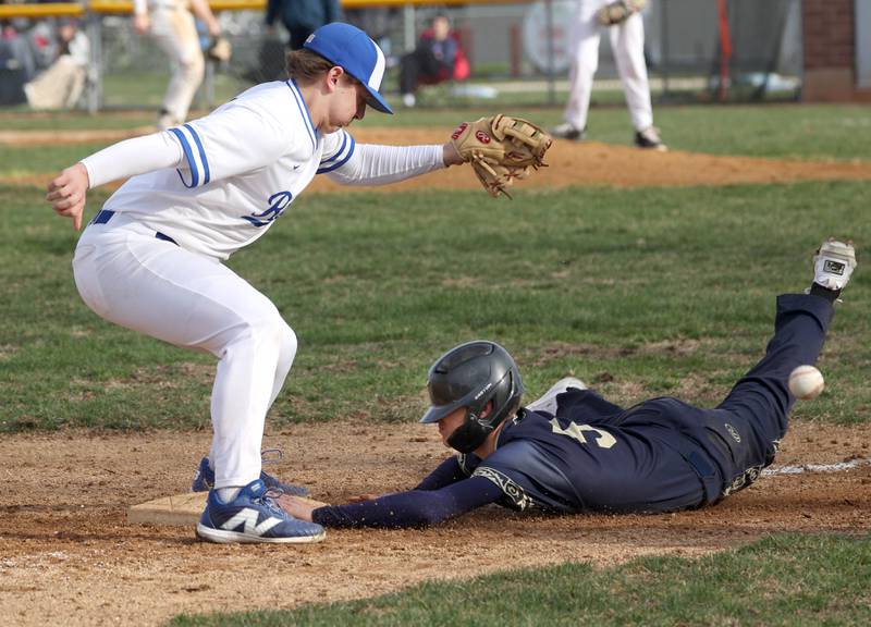 Hinckley-Big Rock’s Luke Badal can’t corral the throw as Polo’s Gus Mumford slides back in safely on a pickoff attempt during their game Thursday, April 3, 2025, at Hinckley-Big Rock High School.
