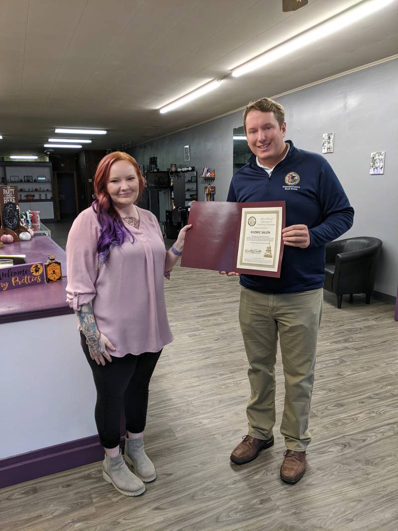 State Rep. Brad Fritts (right) presents a certificate to Kelsey Kutz of Kozmic Salon in Ashton. Fritts spent time touring the business and presented Kutz with a certificate of appreciation for her contributions to the community.