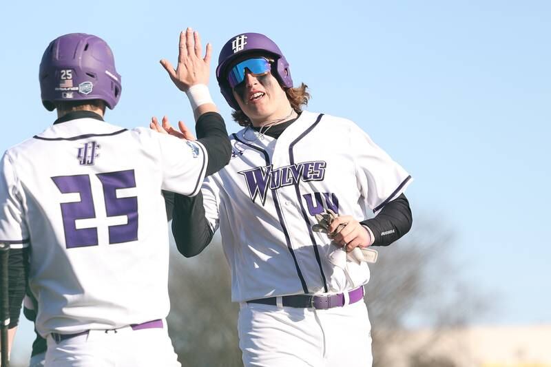 Joliet Junior College’s Preston Vowell high-fives Brendan Sturm after scoring on a hit by Cooper Hertz against Moraine Valley on Tuesday, March 7th, 2023.