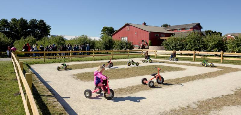 A few kids ride trikes around a farm yard course at Jonamac Orchard in Malta on Wednesday, Sept. 28, 2022.