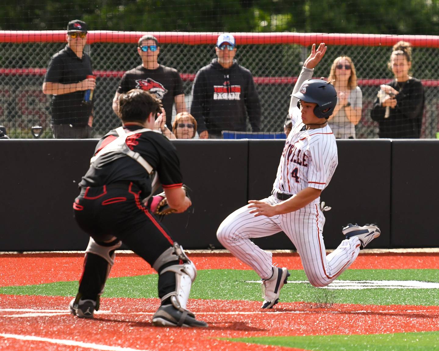 Romeoville's Nolan Holgado (4) slides home safe past Yorkville’s catcher Yorkville's Bryce Baxa (24) during the regional game on Thursday May 29, 2025, held at Yorkville High School.