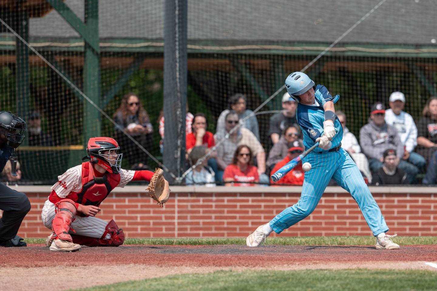 Marquette’s Anthony Couch (24) swings at the pitch with Aurora Christian Catcher Kaleb Elwood (20) waits to catch the ball at Trout Park in Elgin, IL on Saturday May 31st, 2025.  Both teams competed to take home the 1A Sectional Championship Trophy.  Final Score: Marquette 5, Aurora Christian 1