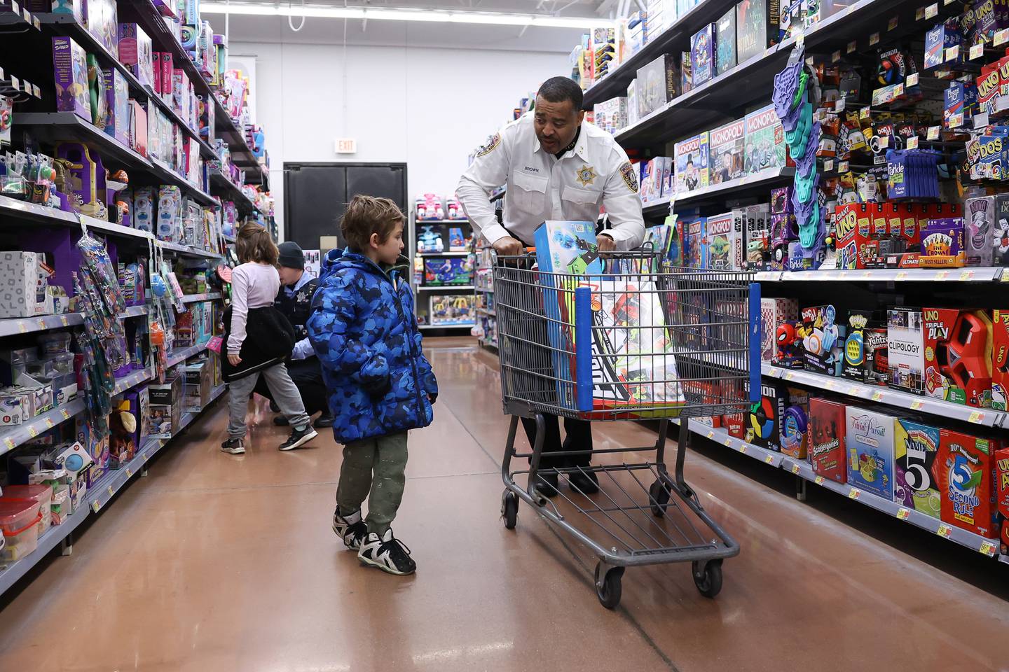 Deputy Police Chief Robert Brown shops with Carter, 7, at the annual Santa Cop at Walmart in Joliet.