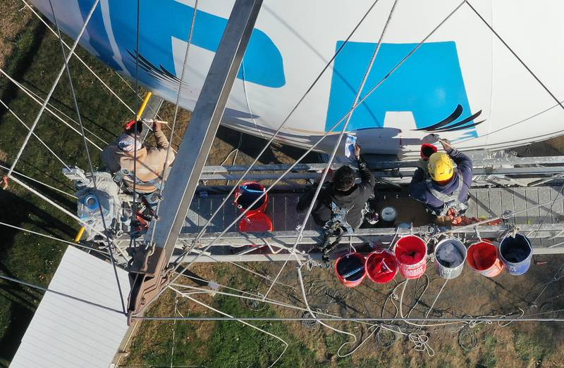 Crews paint the Utica water tower on Friday, Oct. 18, 2024 on top of Clarks Hill in Utica. The Village gave the approval to paint the tower and also conduct repairs inside and out. A Bald Eagle and the State of Illinois is featured on the tower.