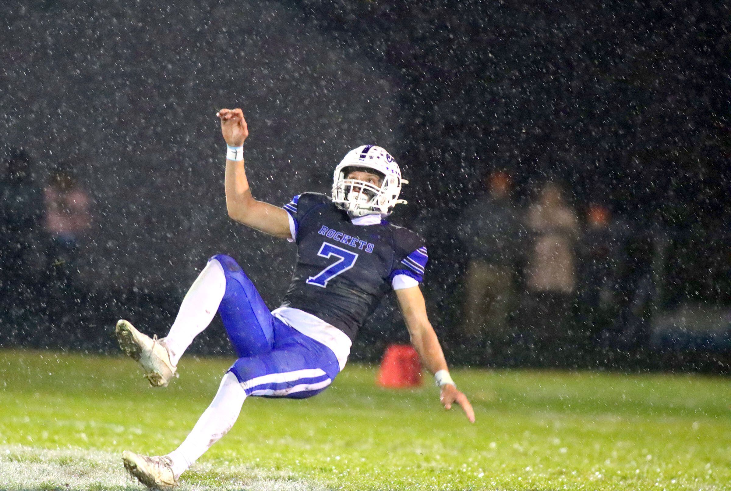 Burlington Central’s Maximilian Gemelli slips on the wet turf after punting against Harlem in IHSA football Class 6A second-round playoff action at Central High School in Burlington on Saturday, November 8, 2025.