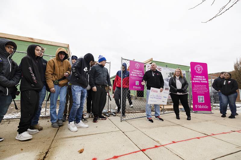 Sterling T-Mobile store manager Brock Burlack presents a check to Sterling Main Street director Janna Groharing Thursday, Dec. 15, 2022 outside of the Shoppes at Grandon Plaza. The $50,000 grant will go toward construction costs for the incubator pods.