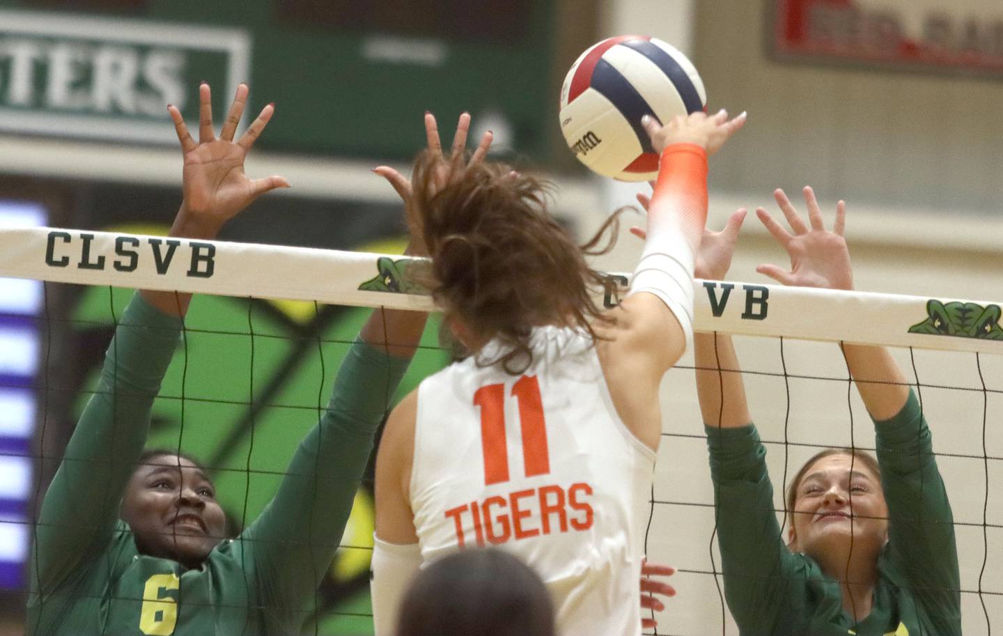 Crystal Lake Central’s Emily Mazza, center, hits the ball between Crystal Lake South’s Sahara Okirika, left, and Bobbi Wire, right, in varsity volleyball at Crystal Lake South High School in Crystal Lake on Tuesday, Oct. 7, 2025.