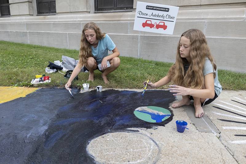 Emily Coppotelli (left), 12, and Lilian Tomasino, 12, both of Dixon, work on an outer space themed painting Thursday, July 4, 2024 during Discover Dixon’s Brush and Bloom event for Petunia Fest.