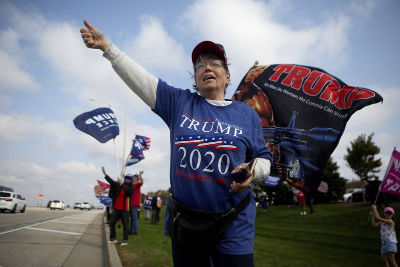 Nancy Visconti cheers at passing cars during a Trump rally at the corner of Randall Road & County Line Road in Algonquin, Ill., on Saturday, Oct. 10, 2020.