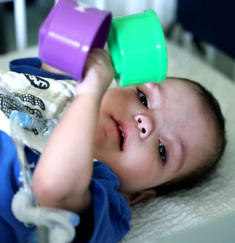 Marely Chavarria Santos, 1, plays in her crib Monday, June 30, 2025, at her home in DeKalb. Marely was born with a myriad of health issues that require around-the-clock care and recently received a heart transplant.