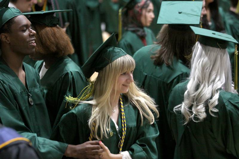 Grace Haase, center, dances with Brendan Hadfield, left, as they prepare to line up for graduation at Crystal Lake South High School in Crystal Lake on Saturday, May 17, 2025.
