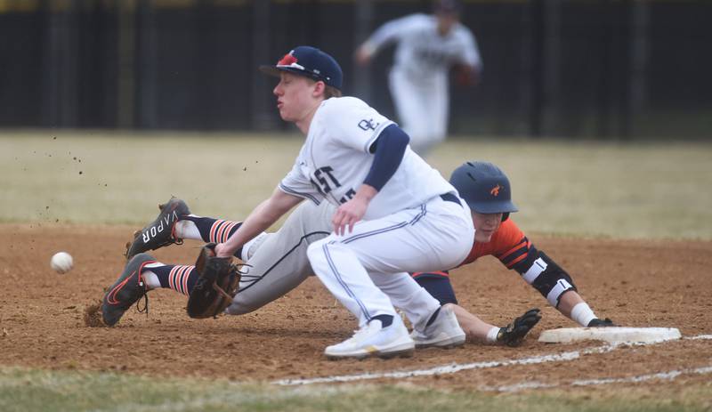 Naperville North's Tanner Mally slides safely back to first base as Oswego East's Cody Hanes waits for the throw during Wednesday's baseball game in Naperville.